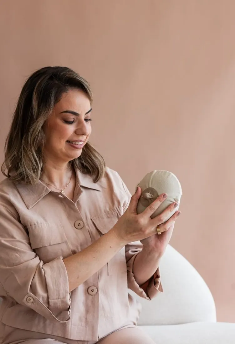Letícia Lamberti segurando um modelo de mama em crochê usado nas orientações