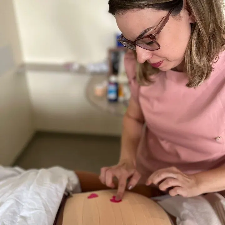 Aplicação de taping na barriga de uma gestante
